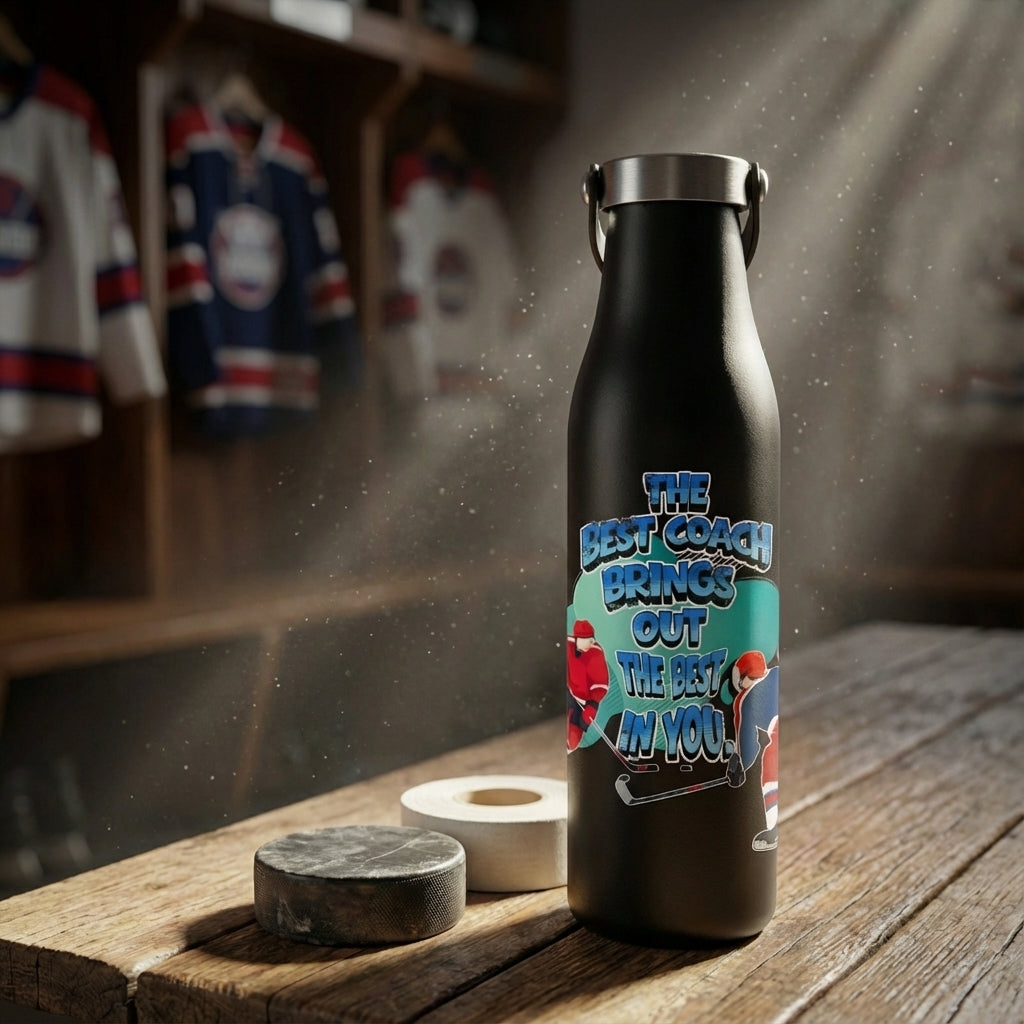 Lifestyle shot - Black LAMOSE Robson 21oz water bottle featuring 'The Best Coach Brings Out The Best In You' design with hockey players, sitting on a bench with a puck and glove.