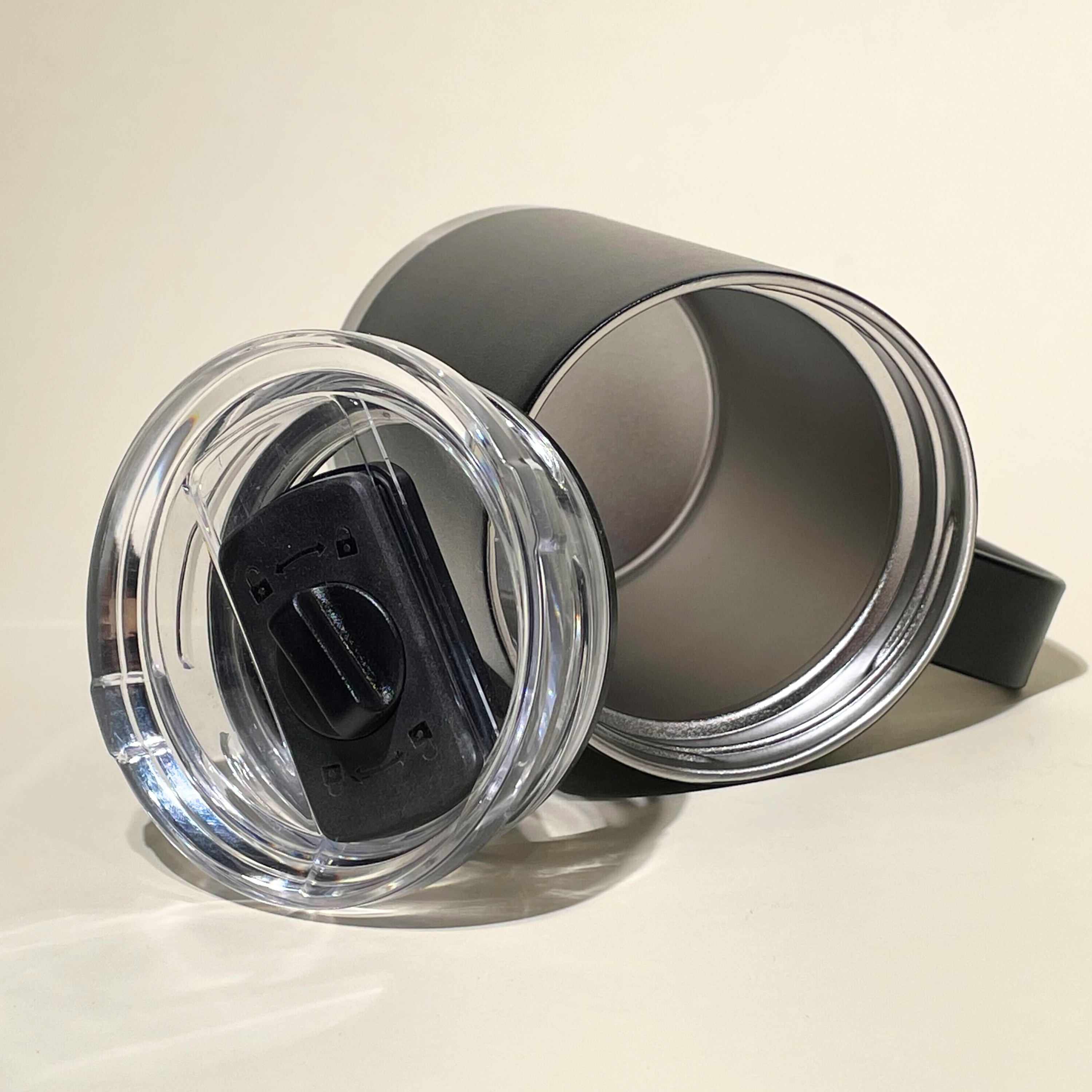 Angled view of LAMOSE Onyx 24 oz stainless steel insulated mug & clear leak-proof lid. Mug shows inner steel, lid has slider lock.