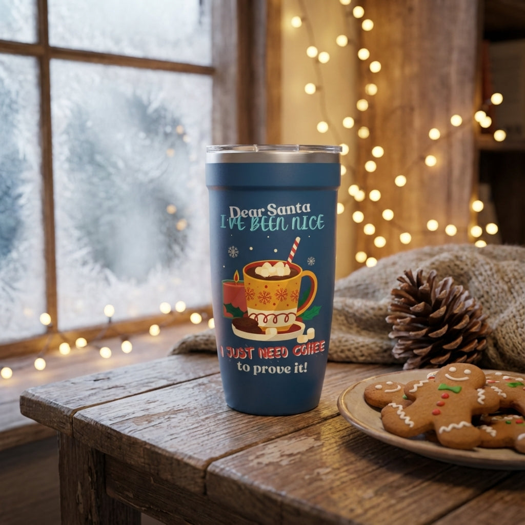 Lifestyle shot - Blue LAMOSE Peyto 16oz insulated tumbler featuring a festive Dear Santa I Need Coffee design with cookies, hot chocolate, and holiday motifs on a wooden table.