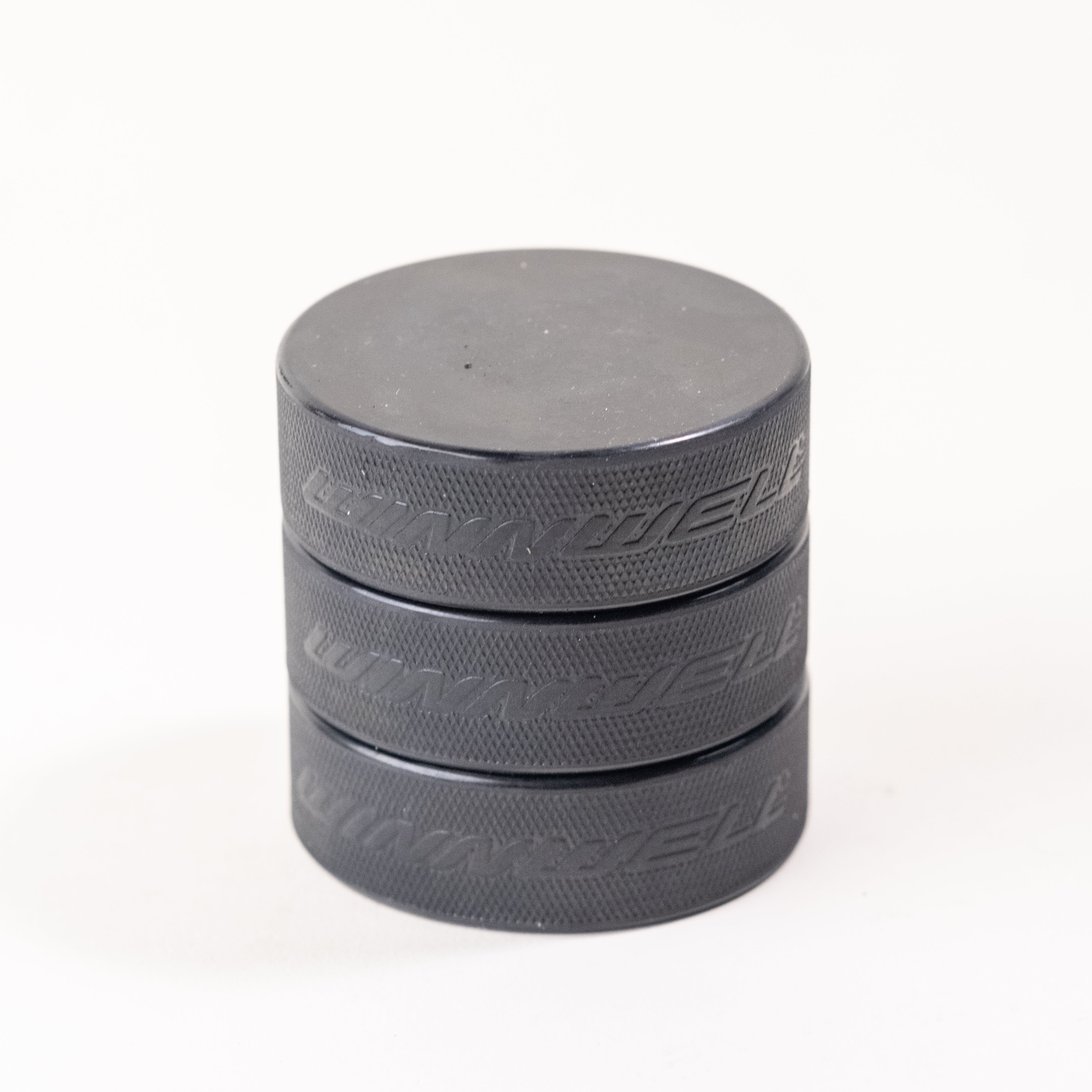 Set of black hockey pucks with textured edges, perfect for games, training, and custom engraving. Official-size durable pucks for players, teams, and coaches.