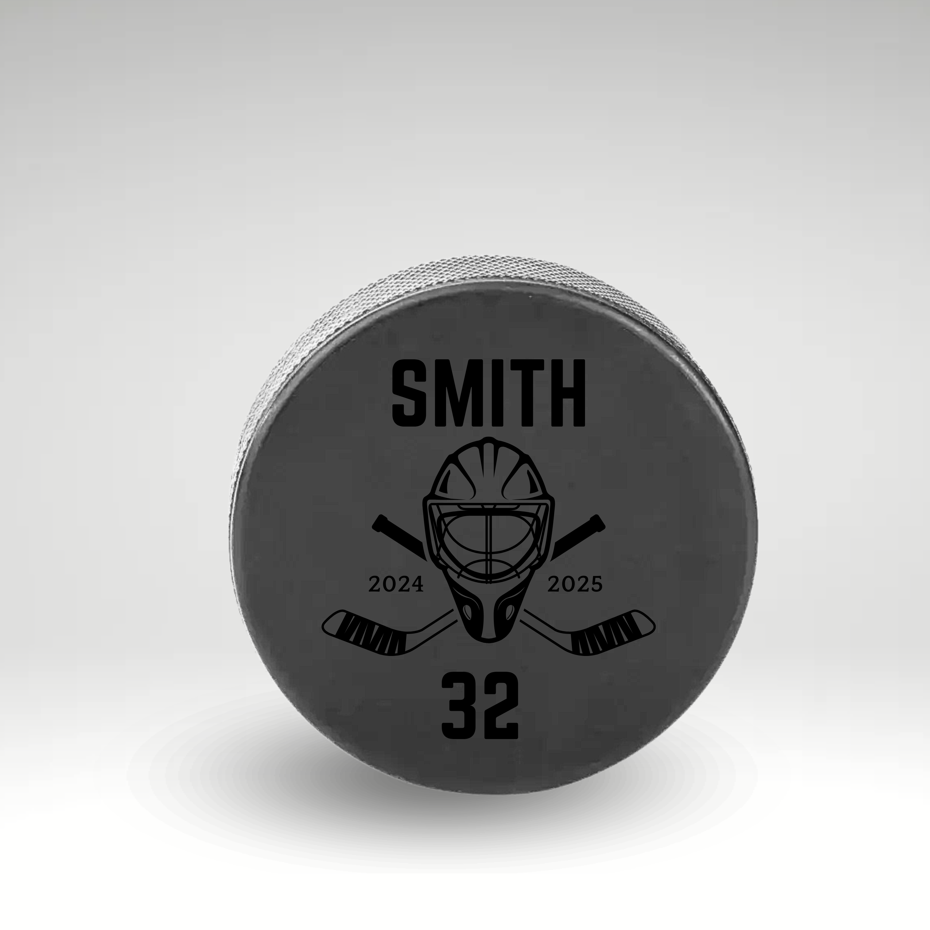 Custom engraved hockey puck for Smith, number 32, featuring a goalie mask and crossed sticks for the 2024-2025 season.