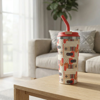 Beige 16oz tumbler with rust, black, and brown geometric shapes sitting on a mid-century modern coffee table