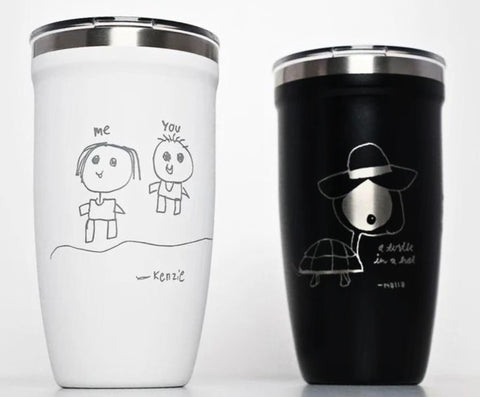 Personalized black mugs and tumblers engraved with children's artwork, names, and special messages, perfect for parents seeking unique keepsakes.