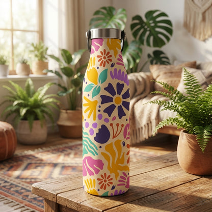 Cream colored LAMOSE Robson 21 oz water bottle featuring vibrant abstract purple, teal, and orange floral pattern sitting on a bohemian rug.