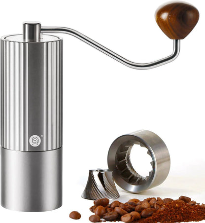 Stainless steel manual coffee grinder with precision burrs, wooden handle, and freshly ground coffee beans for consistent grinding performance
