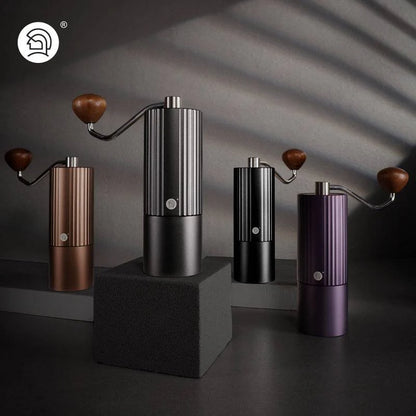 Premium manual coffee grinders in black, bronze, purple, and matte black with a sleek ribbed design, wooden handle, and precision burr grinder for consistent coffee grounds