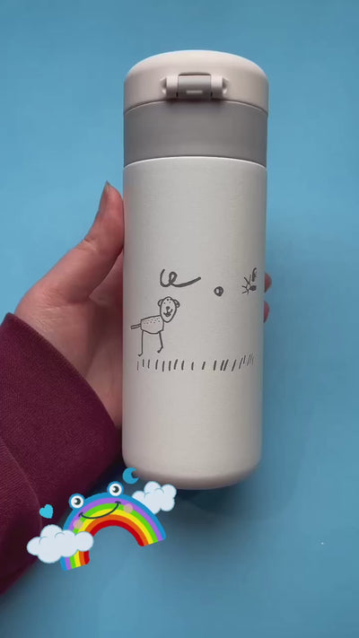 Custom white insulated tumbler with a child’s hand-drawn illustration, featuring a lion and a bee, on a blue background. Personalized travel mug with unique artwork.