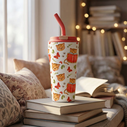 Creamy white 16 oz insulated tumbler featuring illustrated leopard cubs reading books and wearing glasses, resting on a stack of hardcover books in a cozy library setting.